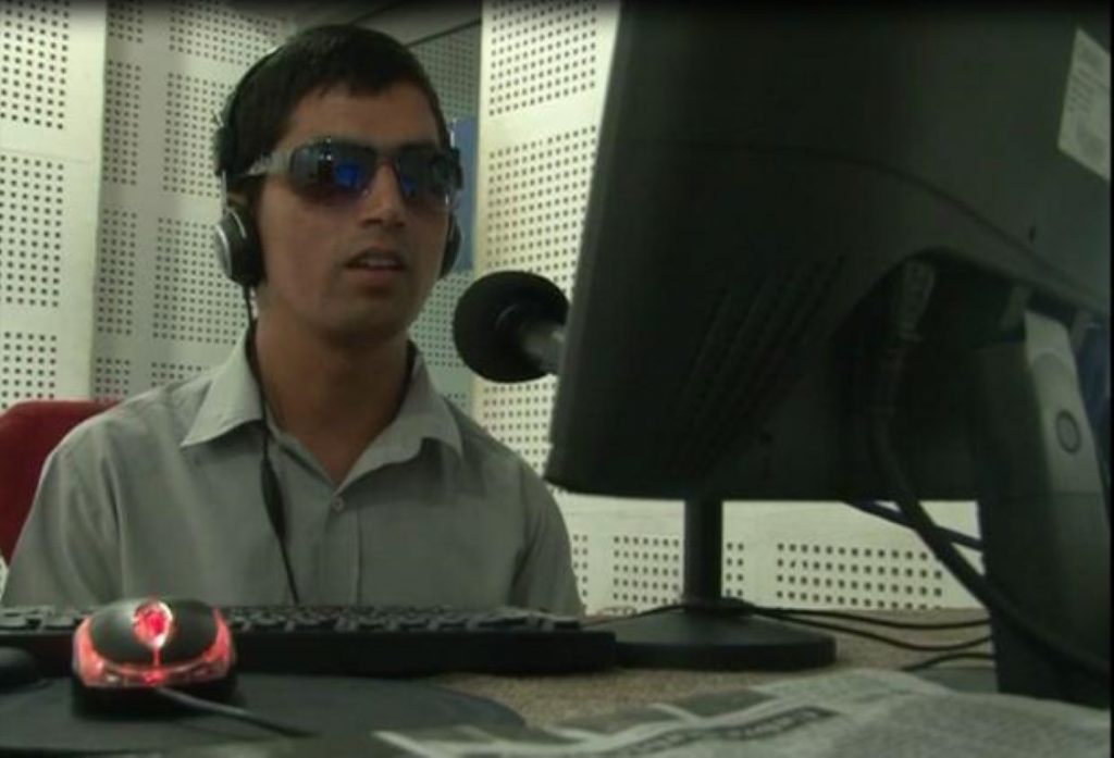 a visually impaired person speaking infront of a mike