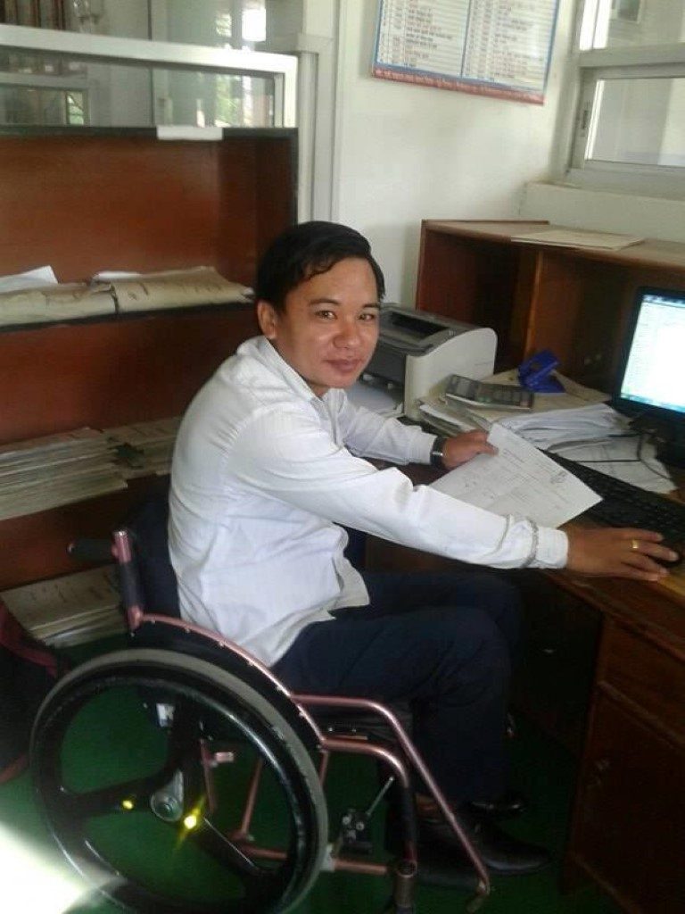 a person in a wheelchair at his workdesk